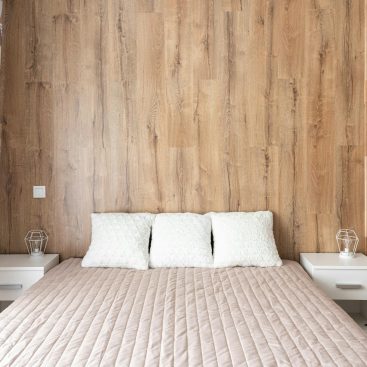 contemporary bedroom interior with bed against wooden wall